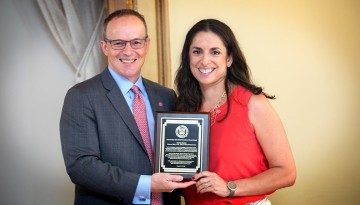 Joel Malina, Cornell vice president for university relations, presents Christa Glazier '01 with the Cornell New York State Hometown Alumni Award