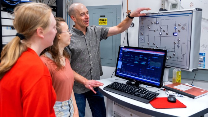 Mike Niemack, professor of physics and astronomy,  works with grad student Alicia Middleton, center, and REU summer undergraduate researcher Isla Steinman in Niemack’s lab in the Physical Sciences Building.