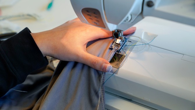 Yu uses a home sewing machine to couch the conductive threads into the seams.