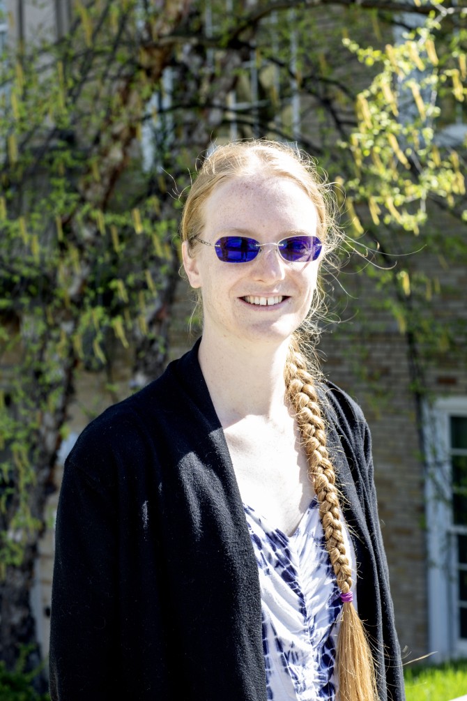 Woman with long blonde hair and tinted glasses