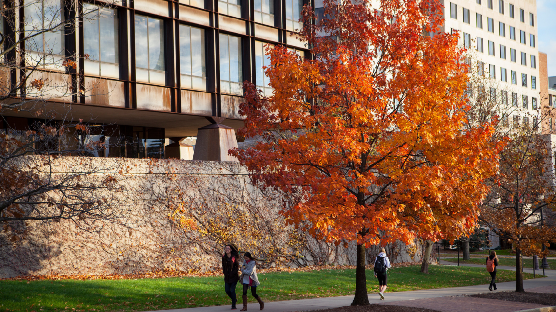 Students walk past Uris Hall in the fall