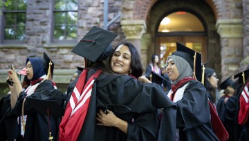 Two graduates hugging. 