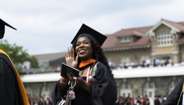 A graduate waves to the crowd. 